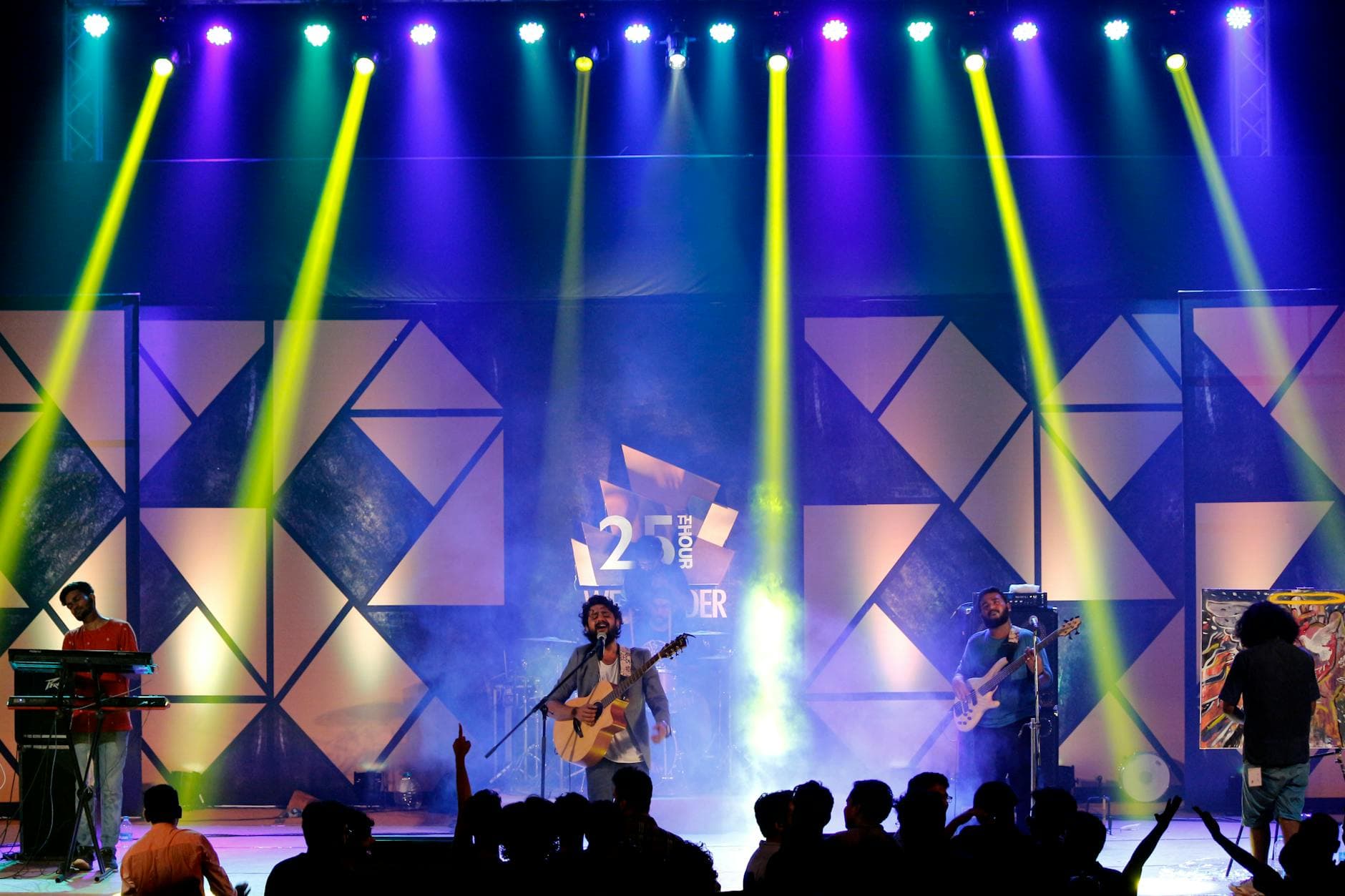 Silhouetted crowd against a geometric stage backdrop