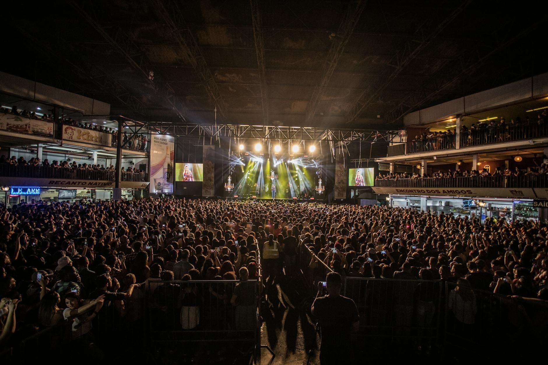 Wide crowd shot from audience POV at a concert